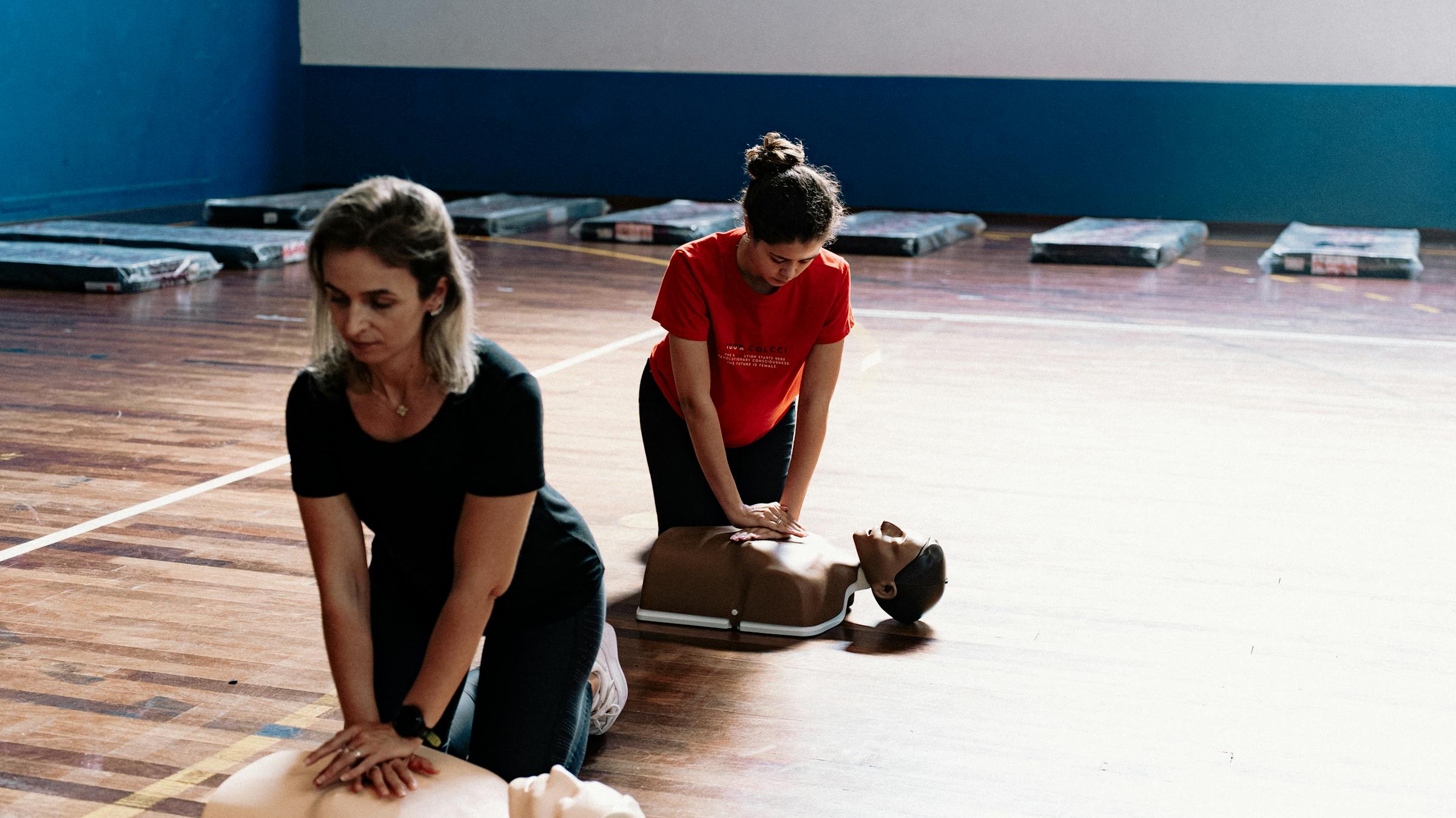 Adults practicing CPR skills on training mannequins